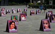 Foto's van slachtoffers, omgekomen door geweld tegen vrouwen. De foto's staan in Medellin, een stad in Colombia. beeld AFP, Joaquin Sarmiento