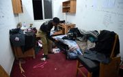 De politie doorzoekt de kamer van de gedode student. beeld AFP