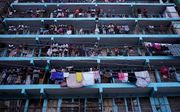 Vanaf balkons kijken mensen naar ongeregeldheden op straat na verkiezingen in Kenia. beeld AFP
