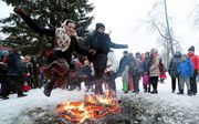 Russen vieren het zogenaamde Pannenkoekenfeest in St. Petersburg. Het feest markeert het einde van de winter. beeld EPA