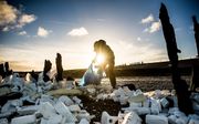 Vrijwilligers ruimen de troep op die op de Waddendijk is terechtgekomen nadat een vrachtschip 270 containers was verloren. De schoonmaakactie is een initiatief van het Zeehondencentrum Pieterburen en Staatsbosbeheer. beeld ANP