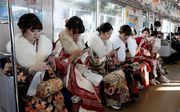 Vrouwen in Tokio zijn onderweg naar huis, nadat ze hun twintigste verjaardag vierden tijdens een groot feest. beeld EPA
