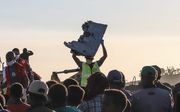 Een hulpverlener houdt een stuk van een gecrashte Boeing 737 Max 8 van Ethiopian Airlines omhoog. Bij het ongeluk kwamen 157 mensen om het leven. beeld AFP