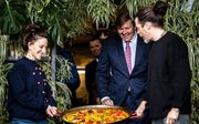 Koning Willem-Alexander ontvangt een grote pan paella van de Spaanse kusntenaar Nacho Carbonell. beeld ANP