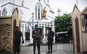 Agenten bewaken een kerk in Colombo, Sri Lanka, na de aanslagen in april. beeld AFP, Jewel Samad