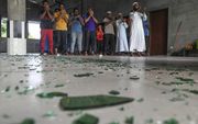 Sri Lankaanse moslims bidden na aanvallen op winkels en bedrijven van moslims. beeld AFP