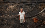 Een Braziliaanse boer tussen de resten van zijn boerderij in de Amazone. beeld EPA