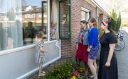De 86-jarige Cornelia Smit-Ligtenberg uit Vinkeveen krijgt raambezoek van haar 5-jarige achterkleindochter Avia (5), schoondochter Christine (50) en kleindochters Kyra (23) en Sara-Maria (24, rechts op de foto) beeld RD, Henk Visscher