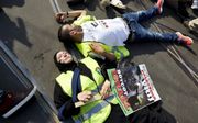 Betogers liggen op de grond om hun steun te betuigen aan de inwoners van Gaza tijdens een demonstratie in het centrum van Amsterdam, Beeld ANP, Martijn Beekman