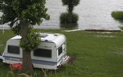 Het Waalwater dreigt camping De Zwaan in Herwijnen te overspoelen. beeld André Bijl