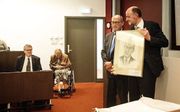 Prof. dr. H. van den Belt (r.) krijgt een schilderij van prof. Graafland uit handen van zoon Wim Graafland. beeld Eran Oppenheimer