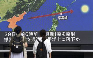 In de Japanse hoofdstad Tokio keken burgers naar de route die de Noord-Koreaanse raket dinsdagochtend aflegde. beeld AFP, Toshifumi Katimura