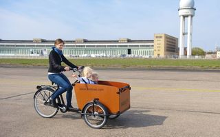 Duitse ouders hebben onder meer het Nederlandse bakfietsenmerk Babboe  ontdekt. Foto: een moeder fiets met haar kroost door het park bij het voormalige vliegveld Tempelhof in Berlijn. beeld Babboe