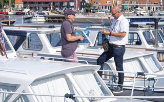 Kroes int het havengeld bij een van zijn gasten in de Elburgse haven. beeld Niek Stam