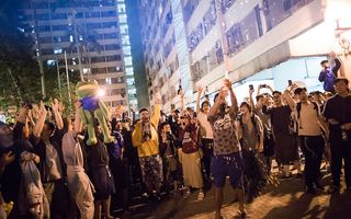Pro-democratie-aanhangers vieren de nederlaag van het pro-Pekingkamp, maandag in Hongkong. beeld EPA, Chan Cheunk Fai