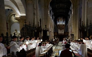 Jongens in wit koortenue. Achterin de kerk het grote orgel.