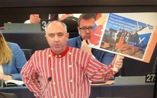 Gestoken in Urker klederdracht vraagt Europarlementariër Peter van Dalen om een extra stemming om het pulsverbod tegen te gaan. In zijn hand houdt hij een foto van een vissersgezin om te benadrukken dat de Nederlandse pulsvissers familiebedrijven hebben e