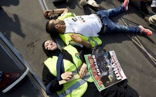 Betogers liggen op de grond om hun steun te betuigen aan de inwoners van Gaza tijdens een demonstratie in het centrum van Amsterdam, Beeld ANP, Martijn Beekman
