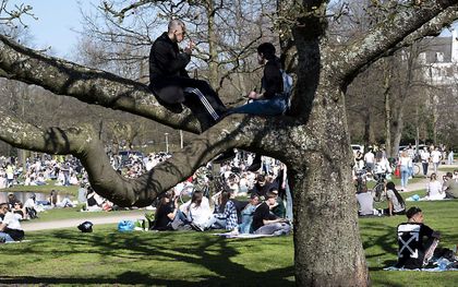 Bezoekers in het Vondelpark in Amsterdam. De toegang tot het park is dinsdag tijdelijk afgesloten omdat het te druk werd vanwege het mooie weer. beeld ANP EVERT ELZINGA