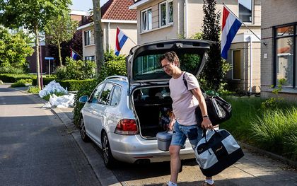De vlag hangt uit bij woningen en zandzakken staan aan straat in de wijk Hambeek als bewoners van de wijk Hambeek hun spullen uitladen. beeld ANP, Vincent Jannink