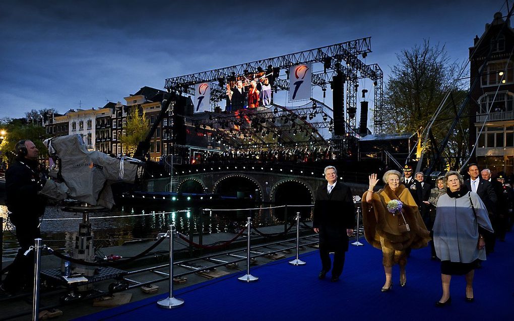 In gezelschap van de Duitse president Joachim Gauck (L) en voorzitter Joan Leemhuis-Stout (R) van het Nationaal Comite 4 en 5 mei arriveert koningin Beatrix voor het jaarlijkse 5 mei-concert op de Amstel in Amsterdam. Foto ANP