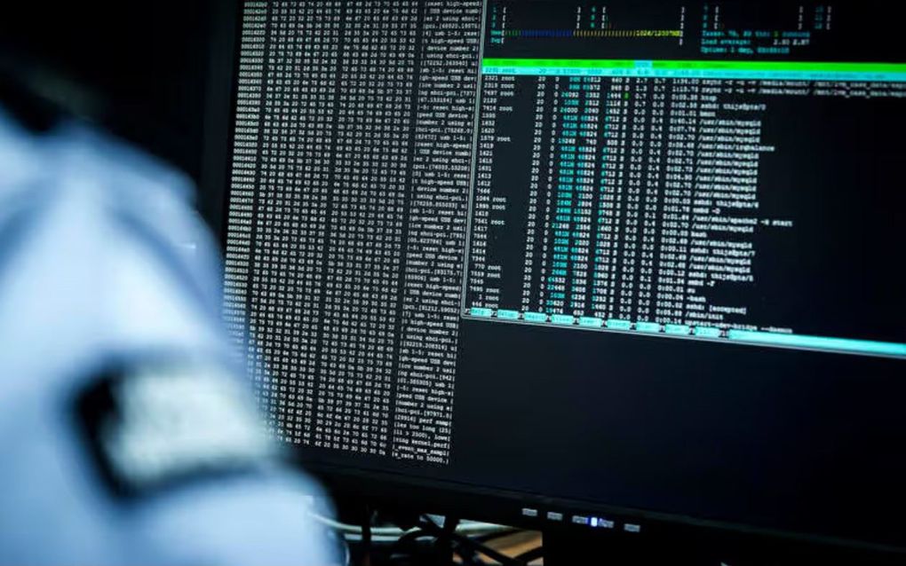 Een militair zit achter een beeldscherm waar gegevens op staan.