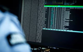 Een militair zit achter een beeldscherm waar gegevens op staan.