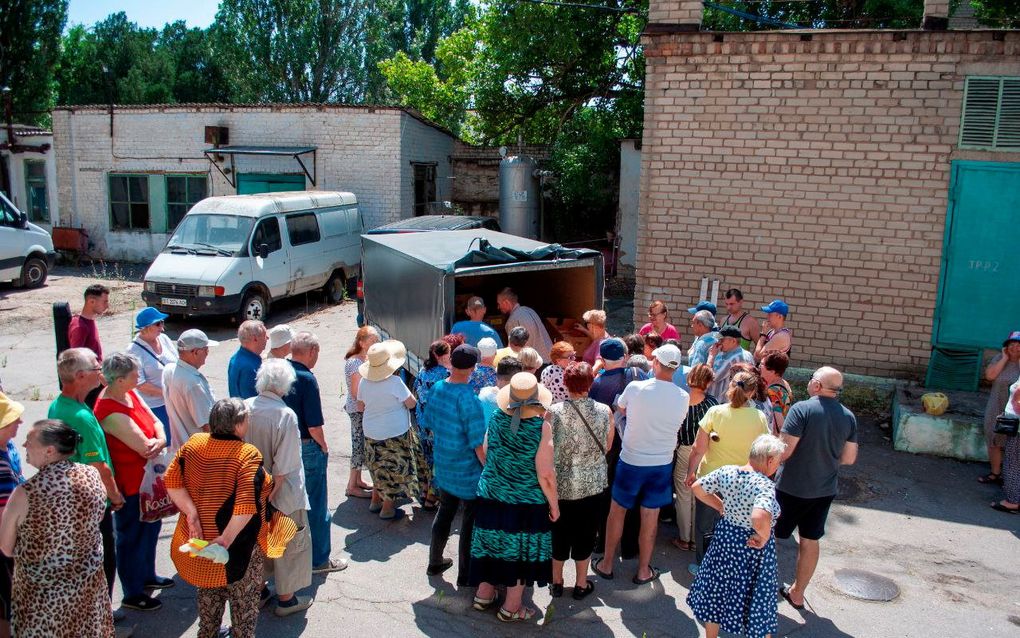 Oekraïners staan in de rij om een voedselpakket in ontvangst te nemen. beeld Arend Steller