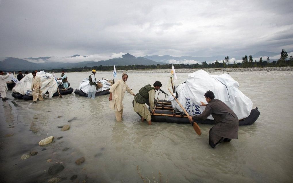 Omdat bruggen zijn verwoest, worden vlotten van vissers in de Pakistaanse Swatvallei ingezet om noodhulp onder de bevolking te verspreiden. Foto Jaco Klamer