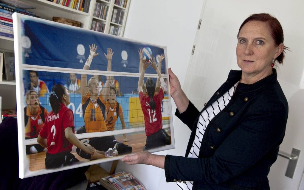 Marijke Roest met een foto met daarop zitvolleyballers. Foto RD, Anton Dommerholt