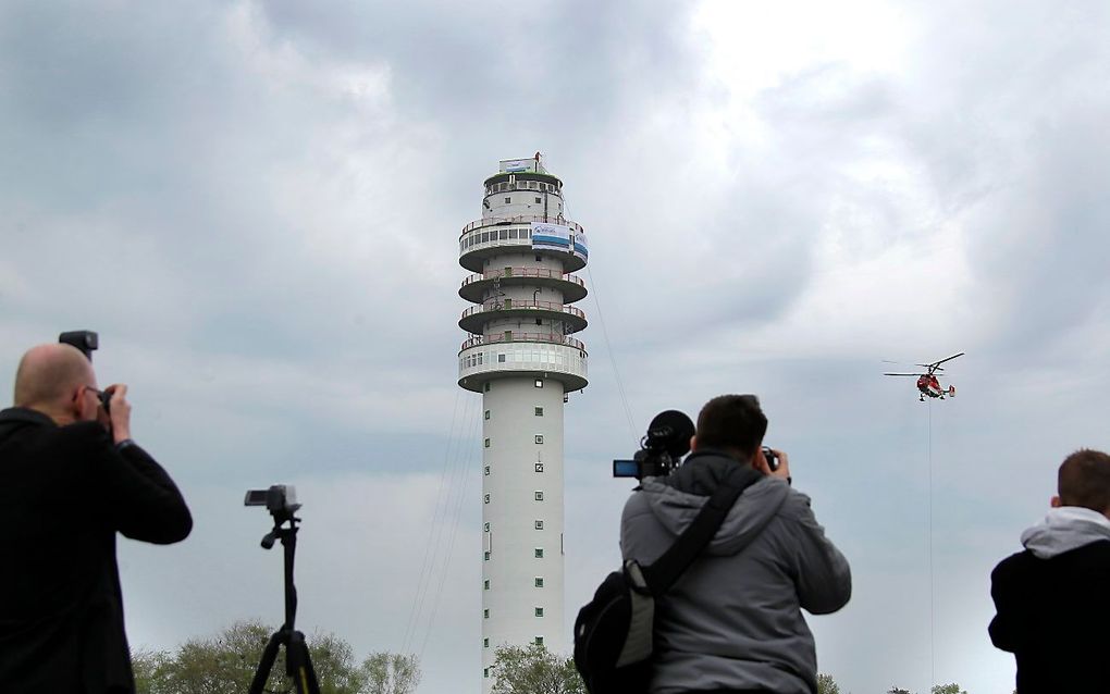 Een speciale helikopter uit Zwitserland hijst dinsdagmiddag het eerste nieuwe mastdeel op de tv-toren in het Drentse Hoogersmilde. De zendmast stortte in juli vorig jaar in na brand. Foto ANP