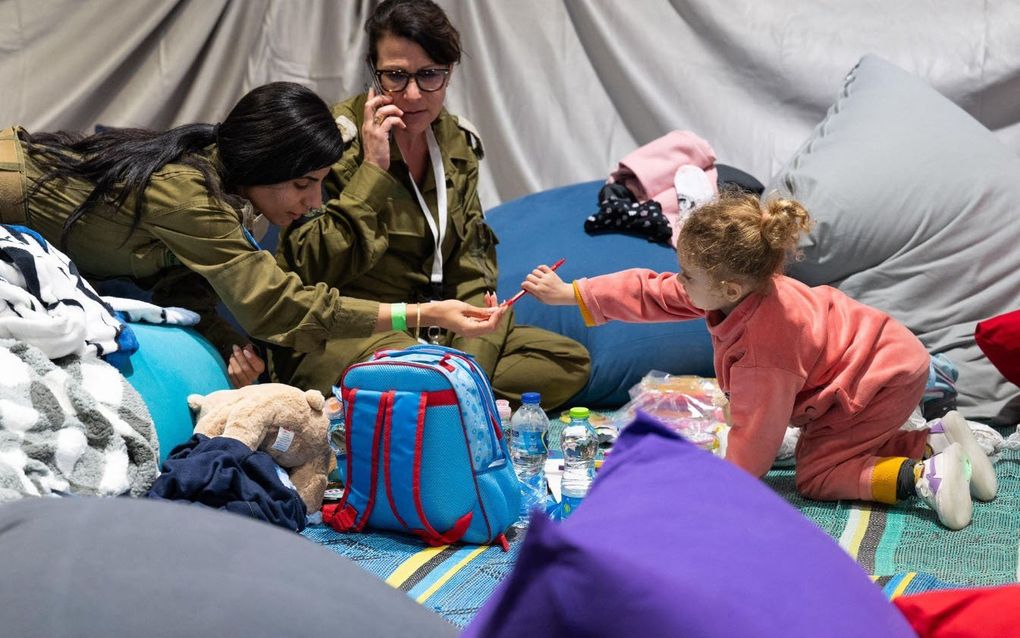 Militairen spelen met een dochtertje van een gegijzelde. beeld AFP