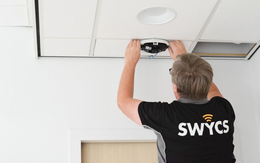 Een medewerker van SWYCS monteert een sensor. beeld SWYCS