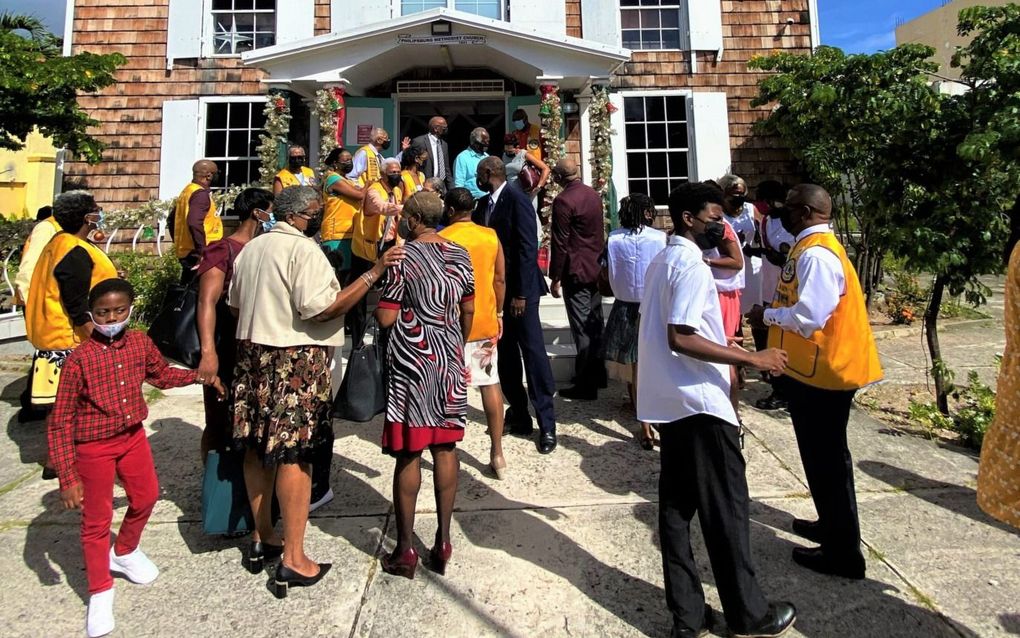 het kerkplein in Philipsburg in coronatijd, tijdens een bezoek van leden van de serviceclub ”Lions”, in oranje hesjes. beeld Marius Bremmer