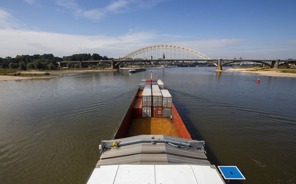 Containers aan boord van een binnenvaartschip op de rivier de Waal bij de Waalbrug bij Nijmegen. Door de lage waterstanden in de Rijn kunnen binnenvaartschepen minder lading meenemen. beeld ANP, VINCENT JANNINK