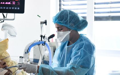 Een zorgmedewerker helpt een coronapatiënt in het Hendri Mondor ziekenhuis bij Parijs. beeld AFP, Alain Jocard