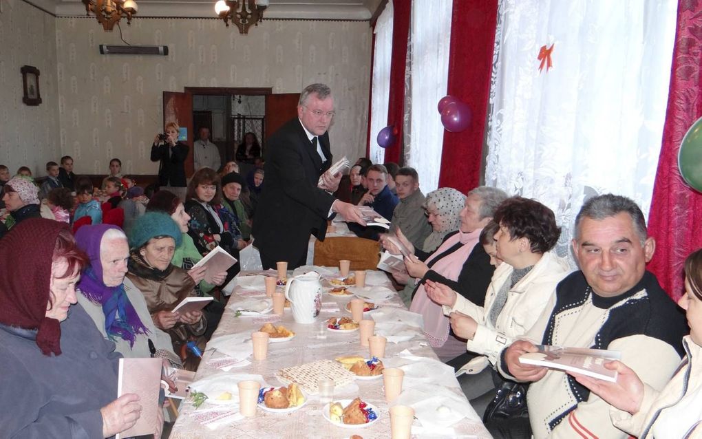 Ds. A. Schot deelt de Russische uitgave van zijn boek uit (foto genomen in 2014). beeld deputaatschap Israël (GG)