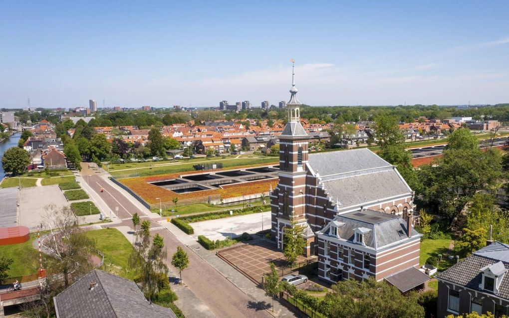 Kerkgebouw en voormalige pastorie van de gereformeerde gemeente te Leiderdorp. Op de achtergrond de tunnelbak van de A4 en links de Oude Rijn. beeld Cees van der Wal