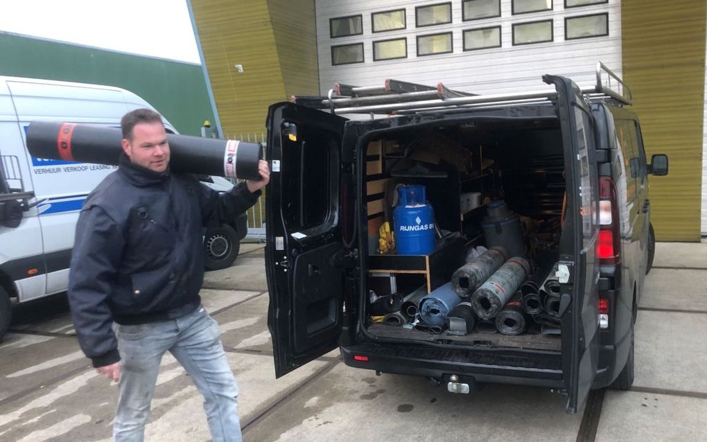 Dakdekker Douwe Schippers laadt dakmateriaal in zijn bedrijfsbus. beeld RD