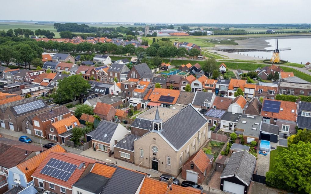 Het kerkgebouw van de oud gereformeerde gemeente in Nederland te Sint Philipsland aan de Achterstraat. Erachter staat het verenigingsgebouw. In de straat erachter, de Voorstraat, is het kerkgebouw van de gereformeerde gemeente te zien. Links achter de bomen staat de eeuwenoude hervormde kerk. beeld Cees van der Wal