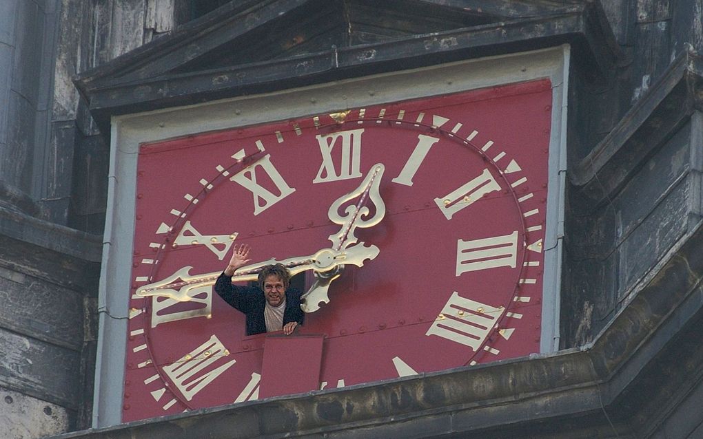 Beiaardier Zwart zwaait vanuit het koekoeksluikje in de Westertoren naar het publiek beneden. Foto Michel Honig