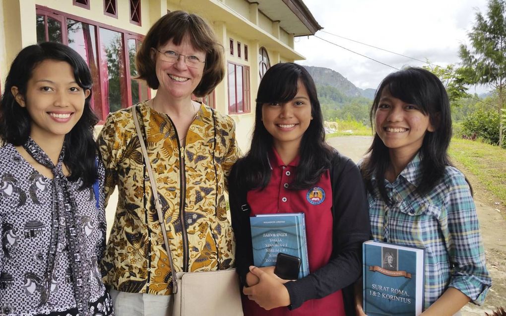 Trekker van het project was voormalig zendingswerkster Barry van der Schoot. Zij werkte eerst voor Oikonomos en later als directeur van de Stichting Vrienden van Matthew Henry. Foto: Van der Schoot met Indonesische studenten theologie met een van de delen van de verklaring. beeld Stichting Vrienden van Matthew Henry