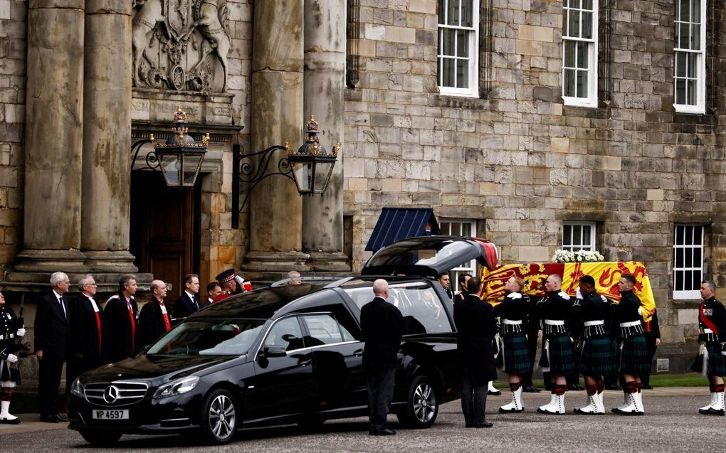 Dragers met de kist voor de overleden koningin Elizabeth, bij het paleis van Holyroodhouse in Edinburgh. Maandag wordt het lichaam van de overleden koningin overgebracht naar de kathedraal van St. Giles in Edinburgh. beeld AFP