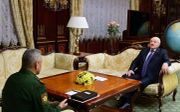 De Russische defensieminister Sergei Shoigu zaterdag tijdens een ontmoeting met de Wit-Russische president Aleksander Loekasjenko.  beeld EPA