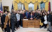 De Amerikaanse president Trump poseert met evangelicale aanbiddingsleiders die hij had gevraagd om op 6 december 2019 in de Oval Office voor hem te bidden. beeld White House, Tia Dufour