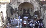 Kerkdienst in de ruïne van de afgebrande Mar Girgiskerk in Cairo. beeld WWM