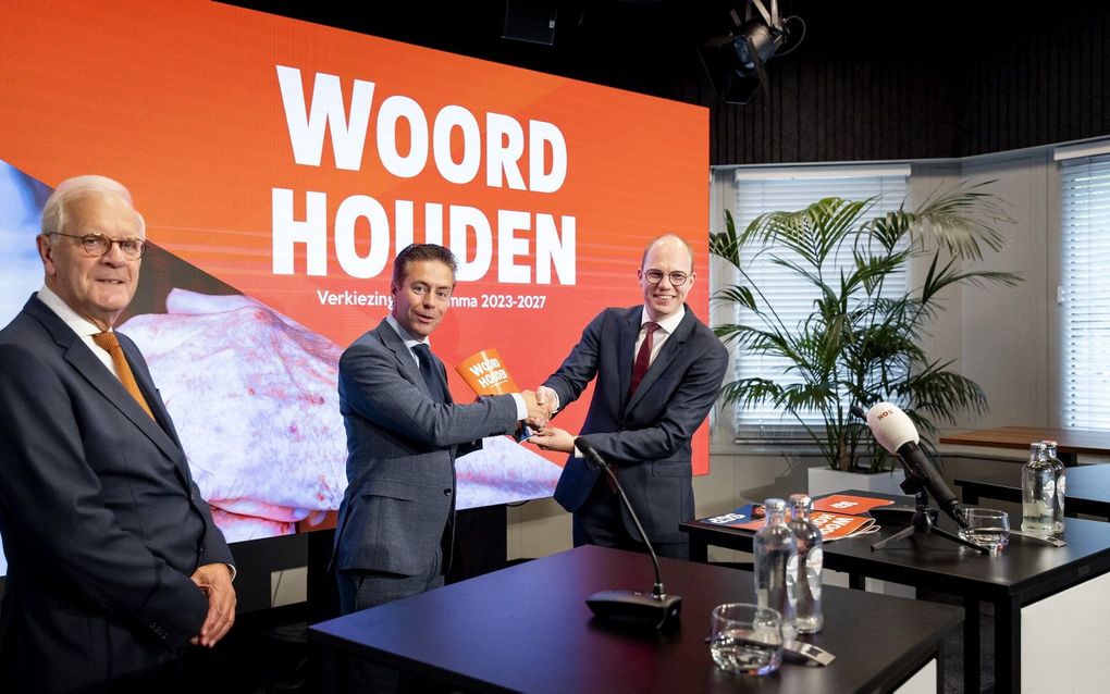 Voorzitter van de verkiezingsprogrammacommissie  Ardjan Boersma (r.) overhandigde vrijdag in perscentrum Nieuwspoort het eindresultaat aan SGP-lijsttrekker Chris Stoffer (m.). Links partijvoorzitter Dick van Meeuwen. beeld ANP, Koen van Weel