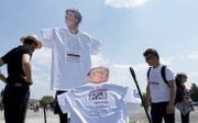 ”Geef Gates geen kans”, waarschuwen betogers in Duitsland tijdens een demonstratie tegen Gates en bondskanselier Merkel. beeld EPA, Ronald Wittek