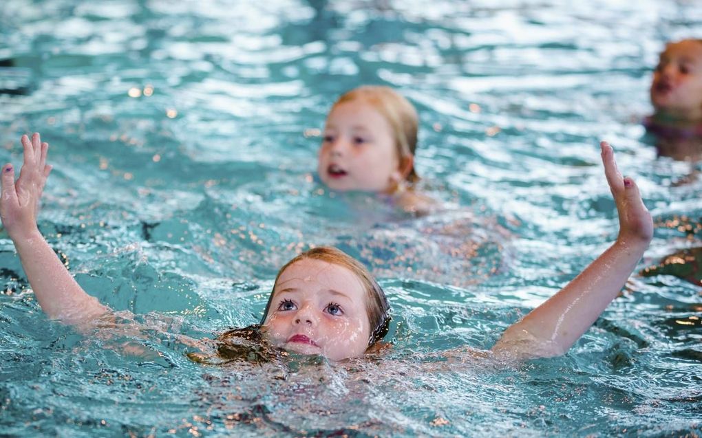 Kinderen doen in het zwembad dappere pogingen om te zwemmen.  beeld ANP, Marco de Swart