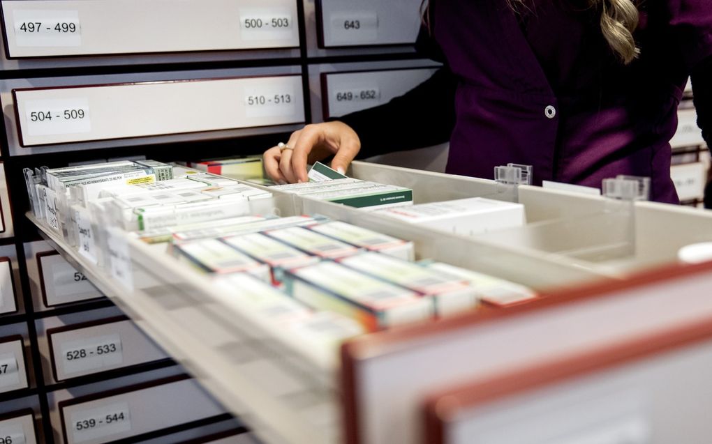 Een apothekersassistente zoekt medicijnen bij elkaar in een apotheek. beeld ANP, Koen van Weel